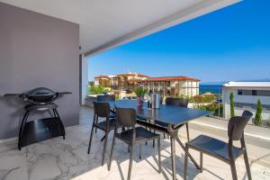 une salle à manger avec une table et des chaises bleues dans l'établissement HADRIE LUXURY RESORT AND VILAS Rova, à Malinska