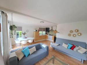 a living room with two blue couches and a kitchen at Villa Present - Chalet Heinkenszand VP008 in Heinkensand