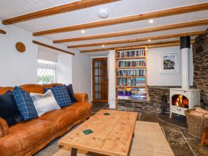 un soggiorno con divano e camino di Crab Cottage a Delabole