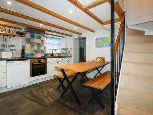 una cucina con un tavolo di legno e una scala di Crab Cottage a Delabole
