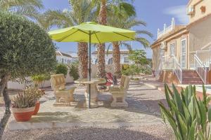 a patio with a table and chairs and an umbrella at Casa El Sole in Mazarrón