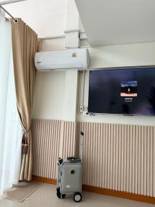 a room with a tv and a suitcase in a room at Cozy house in Sathani Hat Yai