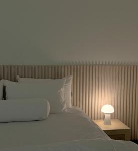a white bed with a lamp on a table at Cozy house in Sathani Hat Yai