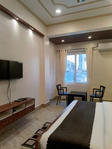 a bedroom with a bed and a flat screen tv at Happy Home Paying Guest House in Varanasi
