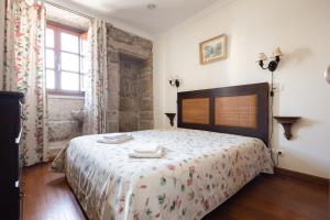 a bedroom with a bed with two towels on it at Casa do Cerrado in Montalegre