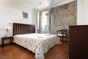 a bedroom with a bed and a brick wall at Casa do Cerrado in Montalegre