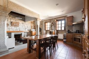 a kitchen with a wooden table and chairs at Casa do Cerrado in Montalegre