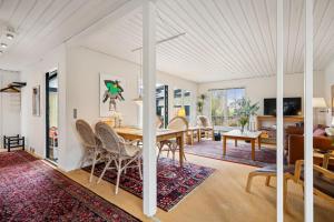 a dining room and living room with a table and chairs at Amazing Home In Ebeltoft With 3 Bedrooms, Sauna And Internet in Ebeltoft