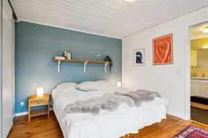 a bedroom with a bed and a blue wall at Amazing Home In Ebeltoft With 3 Bedrooms, Sauna And Internet in Ebeltoft