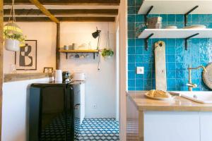a kitchen with blue tiled walls and a refrigerator at Studio Blue LX- 1 de Maio in Lisbon