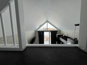 LöbnitzTiny Ferienhaus Oskar 100m Entfernt zum See Strand的白色的房间,设有窗户和楼梯