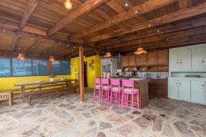 a kitchen with pink stools and a wooden ceiling at Villa Montaña Negra I in Las Palmas de Gran Canaria