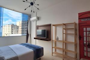 a bedroom with a bed and a window with a phone booth at sétimo andar, excelente vista. in Salvador