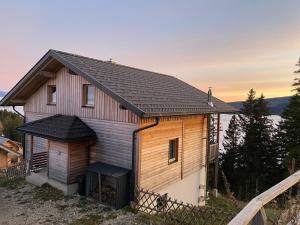 a house with a black roof on a hill at Almchalet Villa Diana in Klippitztorl