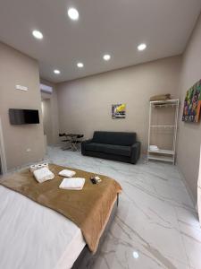 a large bedroom with a bed and a couch at Valentino caracciolo 105 in Naples