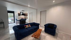 a living room with a blue couch and two chairs at La Cachette in Gallargues-Le-Montueux