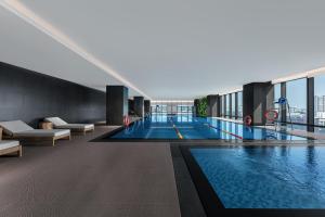 a large swimming pool in a building with a view at Wanda Moments Hotel Beijing Dongba in Beijing