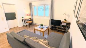 a living room with a couch and a tv at Gästewohnung Köln-Longerich in Cologne