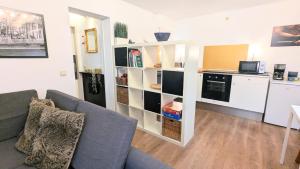 a living room with a couch and a kitchen at Gästewohnung Köln-Longerich in Cologne