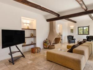 ein Wohnzimmer mit Flachbildfernseher und Couch in der Unterkunft CASALE RONDINELLA 6&2, Emma Villas in Manciano