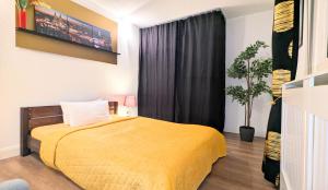 a bedroom with a bed with a yellow blanket at Gästewohnung Köln-Longerich in Cologne