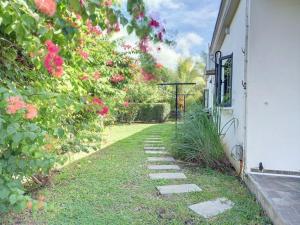 a garden with pink roses on the side of a building at N'joy Pereybere Villa in Pereybere