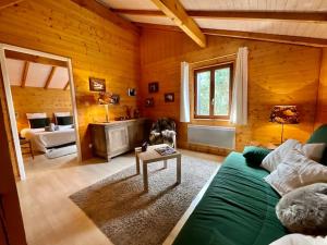 salon z zieloną kanapą i stołem w obiekcie La Charmelle - Belle maison avec jardin & terrasse w mieście Corcieux