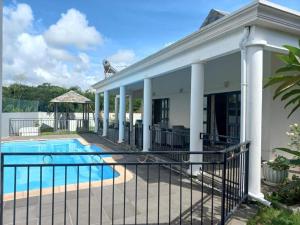 a house with a pool and a fence at N'joy Pereybere Villa in Pereybere