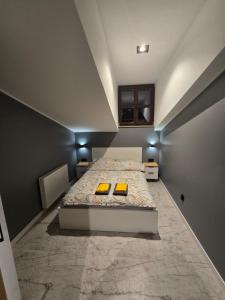 a bedroom with a bed with two yellow cushions at Apartament w Centrum z Jacuzzi, prywatny parking, klimatyzacja 4 in Radom