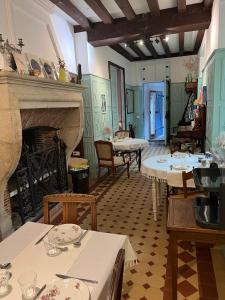 a living room with tables and a fireplace at Le Prieuré de Buffon in Buffon