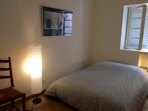 1 dormitorio con cama, lámpara y ventana en Panier, en Marsella
