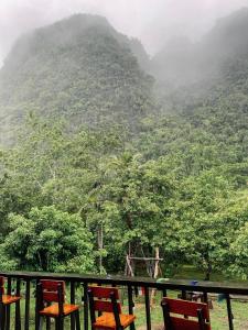 a group of chairs on a balcony looking at a mountain at Khao Sok Green Mountain View in Khao Sok National Park