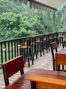 a row of chairs and tables on a balcony at Khao Sok Green Mountain View in Khao Sok National Park