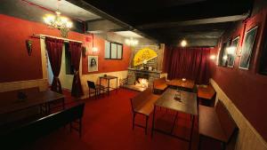 a restaurant with tables and chairs and a fireplace at Pathfinder's Nest Hostel in Darjeeling