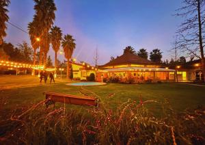 a building with lights in a park at night at Hostería Valle Verde in Villa Alemana