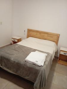 a bedroom with a bed with two night stands and two tables at Edificio San Lorenzo in Corrientes