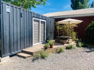 a patio with an umbrella and a wooden deck at Colchagua Tiny Sta Cruz in Nancagua