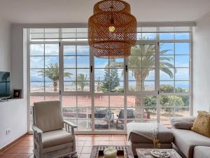 un salon avec une grande fenêtre avec vue sur l'océan dans l'établissement Villa Montana Negra II, à San Bartolomé