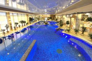 a large pool with blue water in a building at Berejki-Hall in Yegor'yevsk