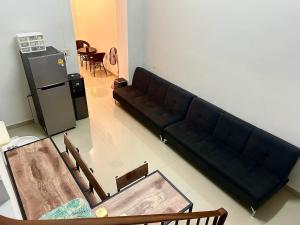 a living room with a black couch and a table at LUB D Betong Hostel in Betong