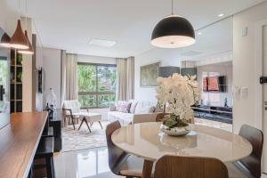 a kitchen and living room with a table and a couch at Apartamento no centro de Gramado in Gramado
