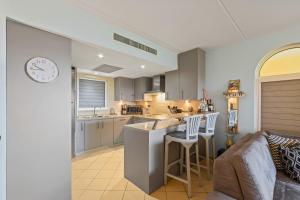 a kitchen and living room with a couch and a clock at Beau Rivage 1 in Willemstad