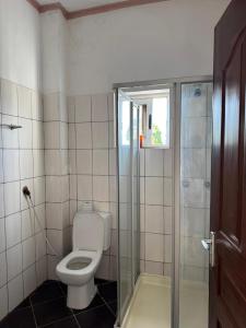 a bathroom with a toilet and a glass shower at Breezy hideaway malindi in Malindi +18 photos