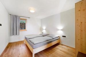 a bedroom with a bed in a room with a window at Hauserhof in Lagundo