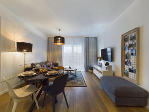 een woonkamer met een tafel en een eetkamer bij Apartments GO Rakowicka by Noclegi Renters in Krakau