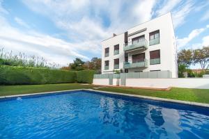 una casa con piscina di fronte a un edificio di WELCS APARTAMENTO 189 PDA con piscina comunitaria a S'Agaró