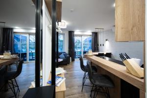 a kitchen and living room with a counter and chairs at Winkelschiffchen III mit Sauna in Juist