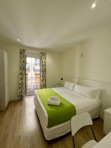 a bedroom with a large white bed and a window at Apartamentos Apolo in Madrid +73 photos