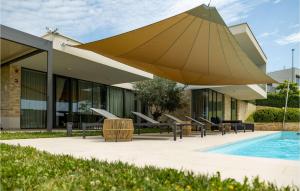 ein großer gelber Regenschirm neben einem Pool in der Unterkunft Villa Rosinjola in Nova Vas