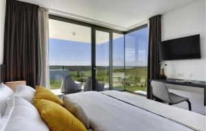 ein Schlafzimmer mit einem großen Bett und einem großen Fenster in der Unterkunft Villa Rosinjola in Nova Vas